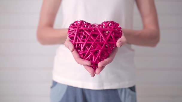 Niña sosteniendo una mimbre en forma de corazón — Vídeos de Stock