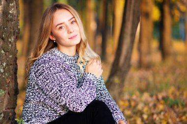 Sonbaharda açık havada yürüyen güzel genç bir kadının portresi..