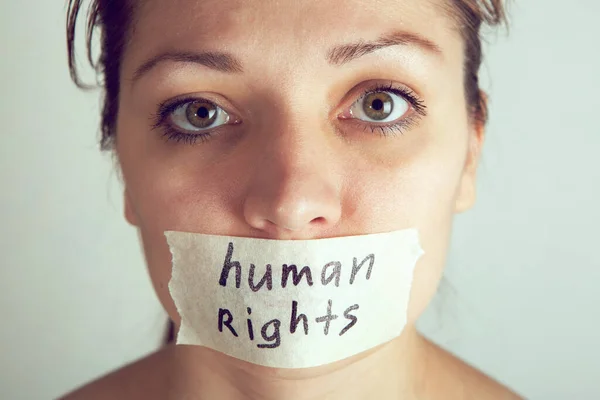 Mujer con la boca envuelta por cinta adhesiva. Día Internacional de los Derechos Humanos —  Fotos de Stock