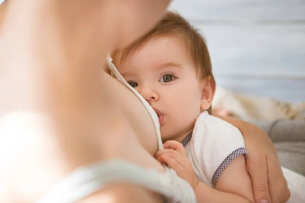 Mamá está amamantando a su bebé en casa. Madre amamantando al bebé en sus brazos en casa —  Fotos de Stock