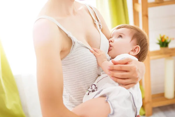 Mom breast feeding baby over window lighting — Stock Photo, Image
