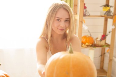 Mutlu Cadılar Bayramı. Mutfakta Cadılar Bayramı için hazırlanan genç bir kadın. Balkabaklı güzel kadın..