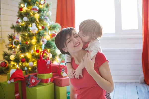 Mutlu aile ve Mutlu Noeller. Anne ve bebek Noel sabahı ağaçta — Stok fotoğraf