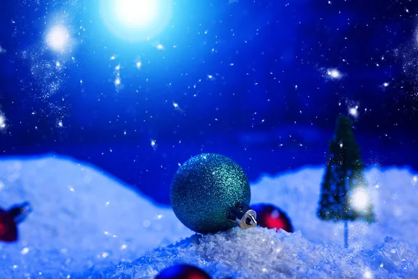 Fundo de Natal com bolas de Natal na neve sobre abeto, céu noturno e lua. Profundidade de campo rasa. Fundo de Natal. Conto de fadas. Macro. Mundo de sonho mágico artificial — Fotografia de Stock