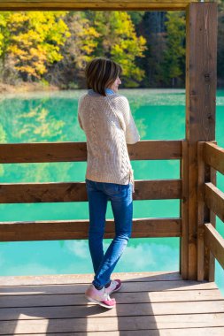 Mavi dağ gölü kıyısında evi olan bir kız. Güzel bir sonbahar sabahı