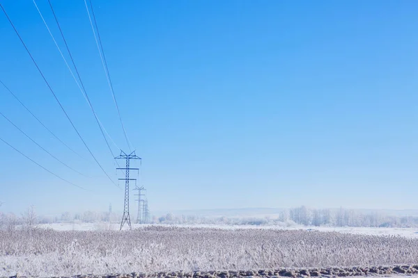 Metal poles high voltage power lineson a winter — Stock Photo, Image
