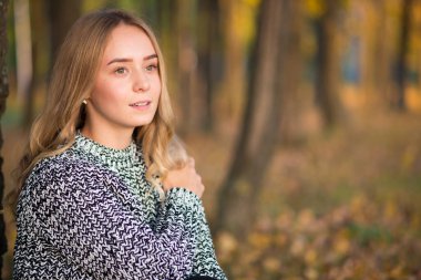 Sonbaharda açık havada yürüyen güzel genç bir kadının portresi..