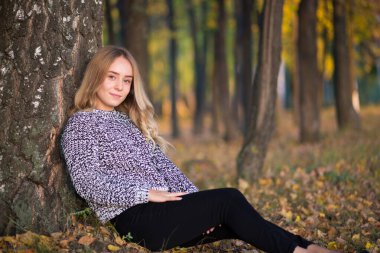 Sonbaharda açık havada yürüyen güzel genç bir kadının portresi..