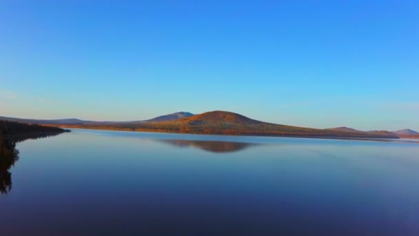 Vídeo aéreo de belo lago de montanha em uma manhã de outono gelada. — Vídeo de Stock