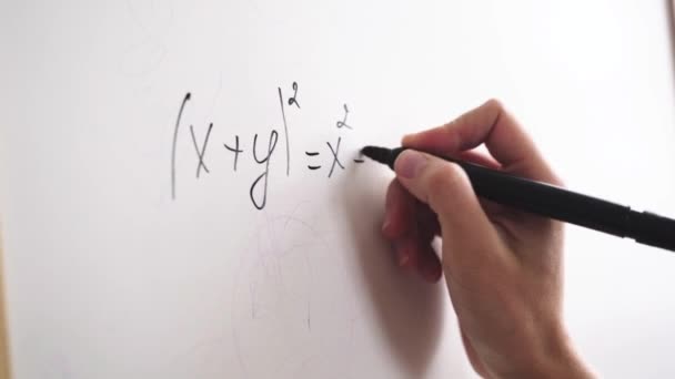 Mão feminina escreve uma fórmula com um marcador em uma placa branca — Vídeo de Stock