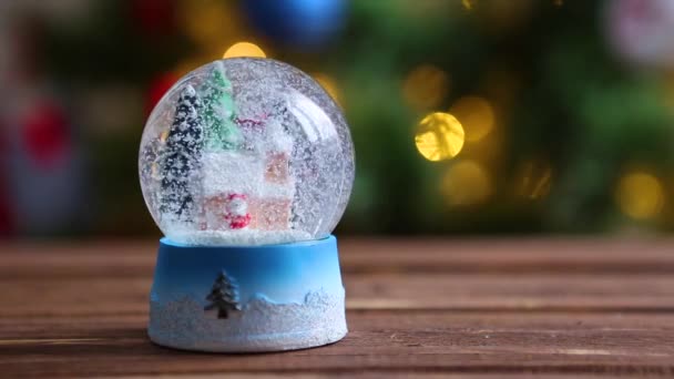 Jul snö glas boll på bakgrunden av julgran med julbelysning — Stockvideo