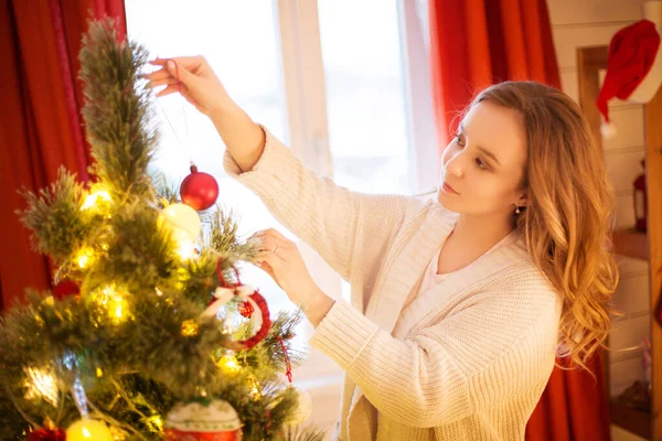 Vacanze di Natale e concetto di Capodanno. Donna allegra decorazione albero di Natale a casa — Foto Stock