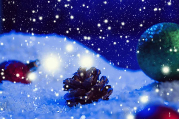 Weihnachten Hintergrund mit Weihnachtskugeln auf Schnee über Tanne, Nachthimmel und Mond. Geringe Schärfentiefe. Weihnachtlicher Hintergrund. Märchen. Makro. Künstliche magische Traumwelt. — Stockfoto