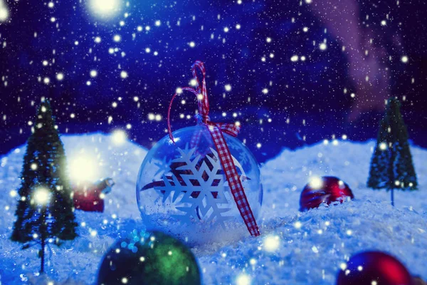 Weihnachten Hintergrund mit Weihnachtskugeln auf Schnee über Tanne, Nachthimmel und Mond. Geringe Schärfentiefe. Weihnachtlicher Hintergrund. Märchen. Makro. Künstliche magische Traumwelt. — Stockfoto