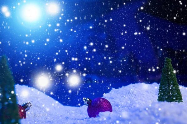 Christmas background with Christmas balls on snow over fir-tree, night sky and moon. Shallow depth of field. Christmas background. Fairy tale. Macro. Artificial magic dreamy world. — Stock Photo, Image