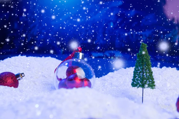 Fundo de Natal com bolas de Natal na neve sobre abeto, céu noturno e lua. Profundidade de campo rasa. Fundo de Natal. Conto de fadas. Macro. Mundo de sonho mágico artificial. — Fotografia de Stock