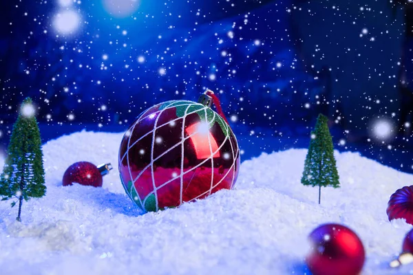 Christmas background with Christmas balls on snow over fir-tree, night sky and moon. Shallow depth of field. Christmas background. Fairy tale. Macro. Artificial magic dreamy world. — Stock Photo, Image