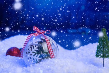 Noel arkaplanı, karla kaplı Noel topları, gece gökyüzü ve ay. Yüzeyin derinliği. Noel arkaplanı. Peri masalı. Makro. Yapay büyü hayal dünyası..