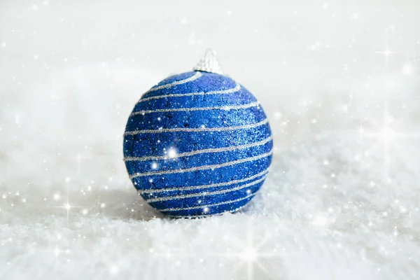 Hermosa bola azul de Navidad en la nieve Hermosas decoraciones de bolas de Navidad se encuentran en la blanca nieve esponjosa. Ambiente de magia y cuentos de hadas — Foto de Stock