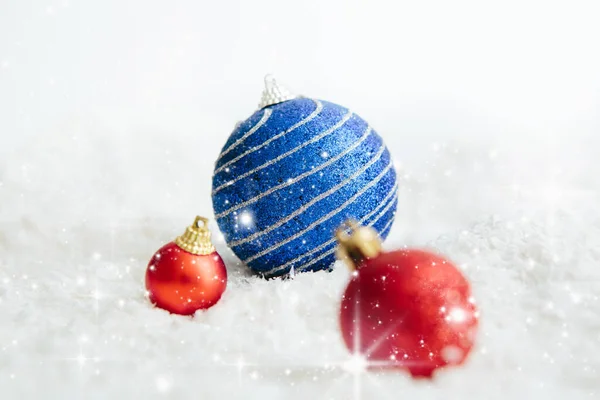 Χριστούγεννα κόκκινο και μπλε μπάλες σε αφηρημένο φόντο Όμορφα στολίδια στολίδια Χριστούγεννα βρίσκονται στο λευκό χνουδωτό χιόνι. Ατμόσφαιρα μαγείας και παραμυθιών — Φωτογραφία Αρχείου