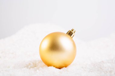 Beyaz arka planda kar üzerinde Noel topları