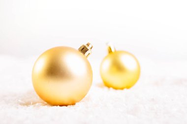 Beyaz arka planda kar üzerinde Noel topları