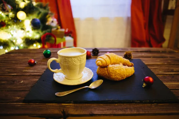 Κούπα με ζεστή σοκολάτα σε ξύλινο τραπέζι με χριστουγεννιάτικες διακοσμήσεις σε φόντο χριστουγεννιάτικου δέντρου — Φωτογραφία Αρχείου