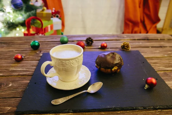 Mug with hot chocolate on a wooden table with Christmas decorations on a background of the Christmas tree — Stock Photo, Image