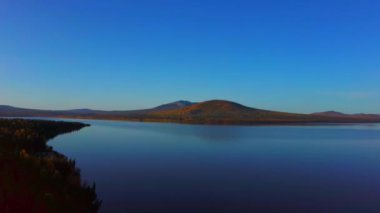 Soğuk bir sonbahar sabahında güzel dağ gölünün havadan çekilmiş videosu..