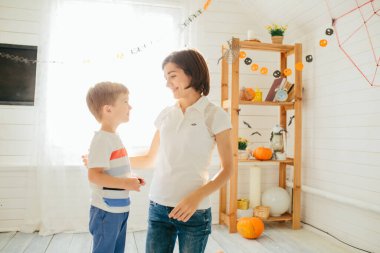 Cadılar bayramın kutlu olsun. Genç, güzel anne ve oğlu balkabağı oyuyor. Mutlu aile Cadılar Bayramı için hazırlanıyor. Mutlu Cadılar Bayramı konsepti