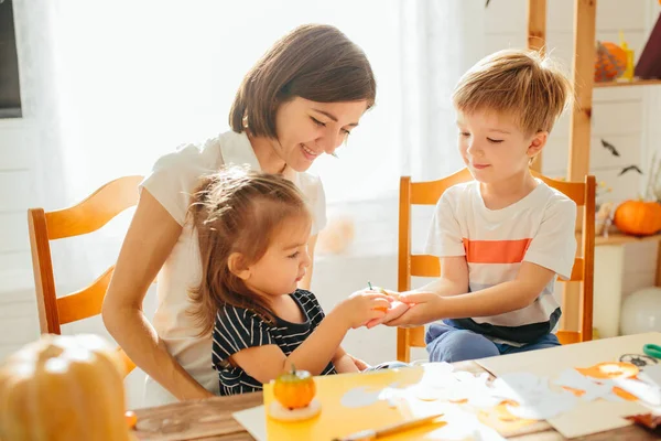 Mother with kids glazing cookies for Halloween celebration Happy Halloween concept — Stock Photo, Image