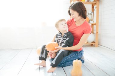 Mutlu anne ve çocuk ailesi, Cadılar Bayramı 'na hazırlanıp evi dekore edin.