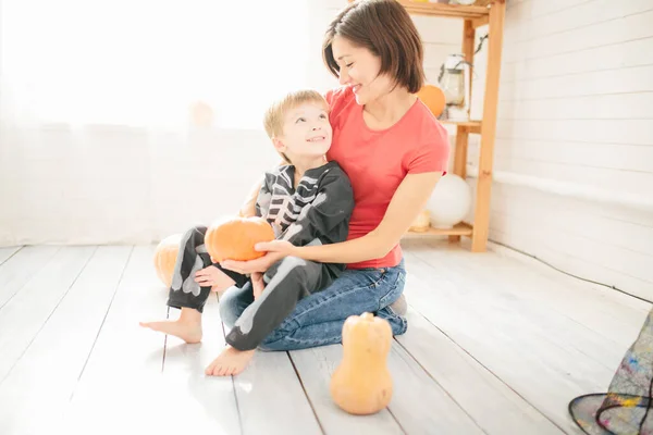 母と子供の幸せな家族は家を飾るためにハロウィーンの準備をします — ストック写真