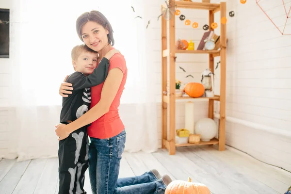 母と子供の幸せな家族は家を飾るためにハロウィーンの準備をします — ストック写真