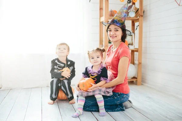 Gelukkig gezin van moeder en kinderen voor te bereiden op Halloween in versieren het huis — Stockfoto