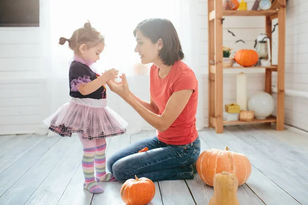 母と子供の幸せな家族は家を飾るためにハロウィーンの準備をします — ストック写真