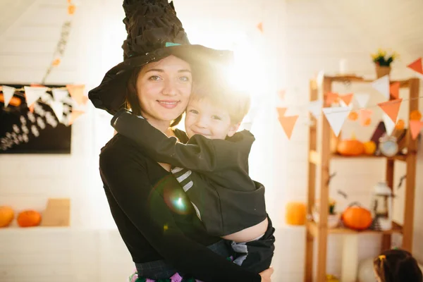 母と子供の幸せな家族は家を飾るためにハロウィーンの準備をします — ストック写真