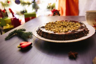 Noel masasında kır evleri ve zencefilli kurabiyeler Glüten ücretsiz Noel fındıklı kek gri bir masada Noel süslemeleri ile.