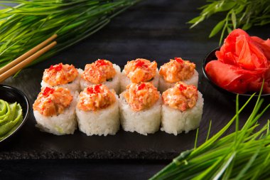 Siyah arka planda wasabi ve zencefilli suşi ruloları. Japon Doğu mutfağı.