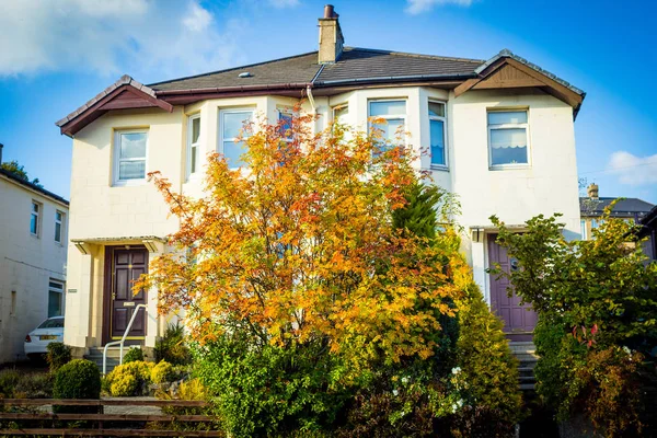 老英国的房子在秋天在一个晴朗的天与秋天叶子在前面 — 图库照片