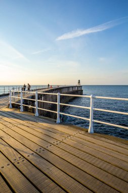 Whitby, İngiltere Turistler Whitby İskelesi ve deniz feneri ziyaret. 12/05/2019