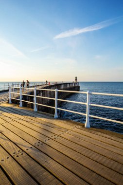 Whitby, İngiltere Mayıs ayında Whitby İskelesi ve deniz feneri ziyaret İngiltere Turistler. 12/05/2019