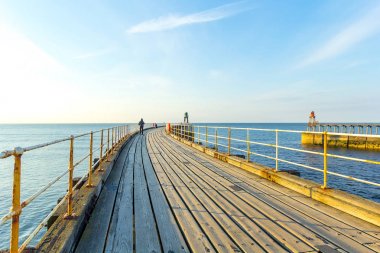 Whitby, İngiltere Turistler Whitby İskelesi ve deniz feneri ziyaret. 12/05/2019