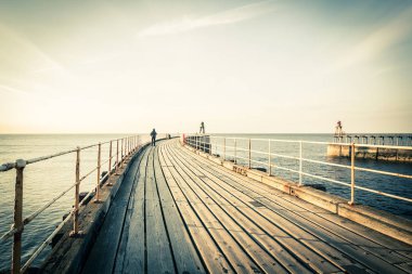 Whitby, İngiltere Turistler Whitby İskelesi ve deniz feneri ziyaret. 12/05/2019