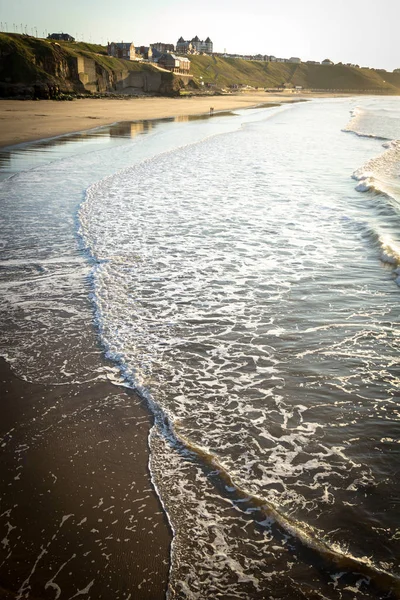 イギリスのウィットビー晴れた日 風の強い日にウィットビービーチを歩く人々 ウィットビー ノースヨークシャー イングランド — ストック写真