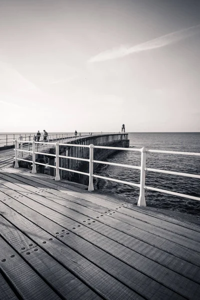 Whitby, İngiltere Whitby İskelesi ve deniz fenerini siyah beyaz ziyaret ediyor.12.05.2019