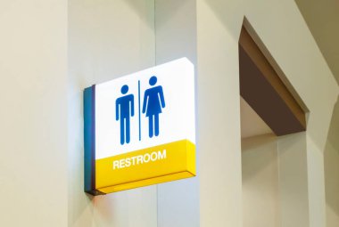 Tuvalet levhası ya da tuvalet levhası. Beyaz beton arka plan, modern, hijyen ve temiz tuvalet konsepti üzerinde kadın ve erkek ikonu sembolü olan elektrik lambasından yapılmış.