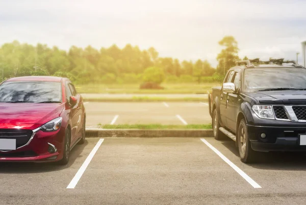 빨간색과 자동차는 아스팔트 주차장에 주차되어 나무들이 줄지어 파란색 하늘이 배경이 — 스톡 사진