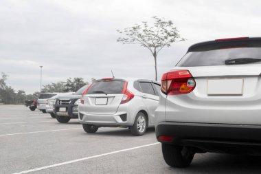 Asfalt caddesindeki otoparkta gümüş renkli SUV otoparkı, araba gezisi doğa kontrolünde.