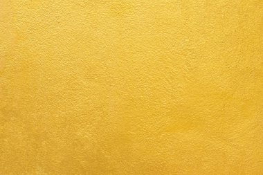 Altın duvar dokusu arka plan. Beton duvarda sarı parlak altın boya. Hafif yansımalı serface, parlak altın renkli duvar kağıdı kılıfı.